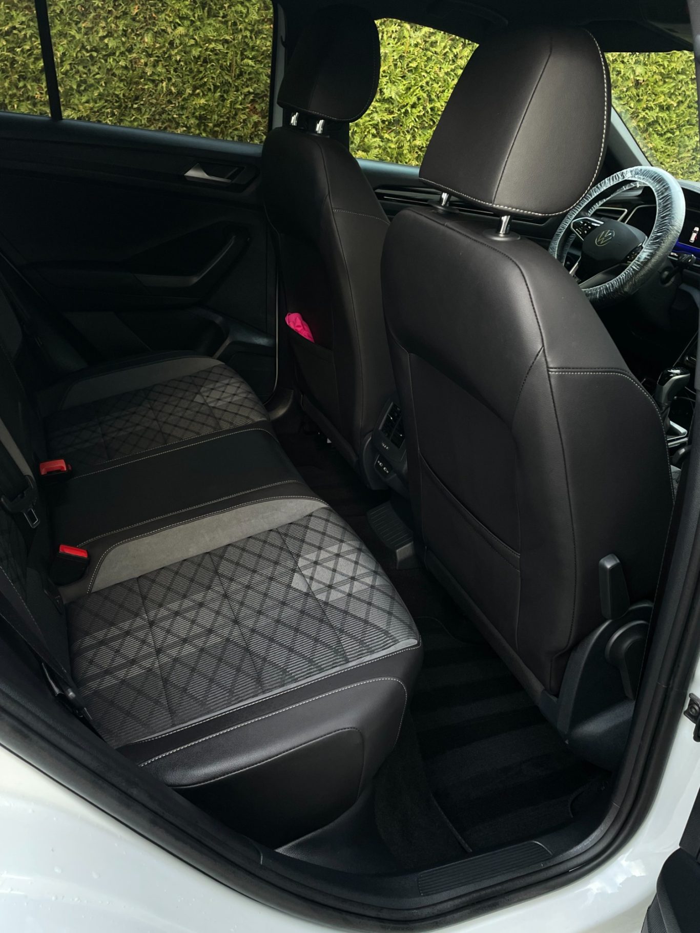 Ein Blick auf die Rücksitze eines Autos mit schwarzen Polstern und grauen Mustern.