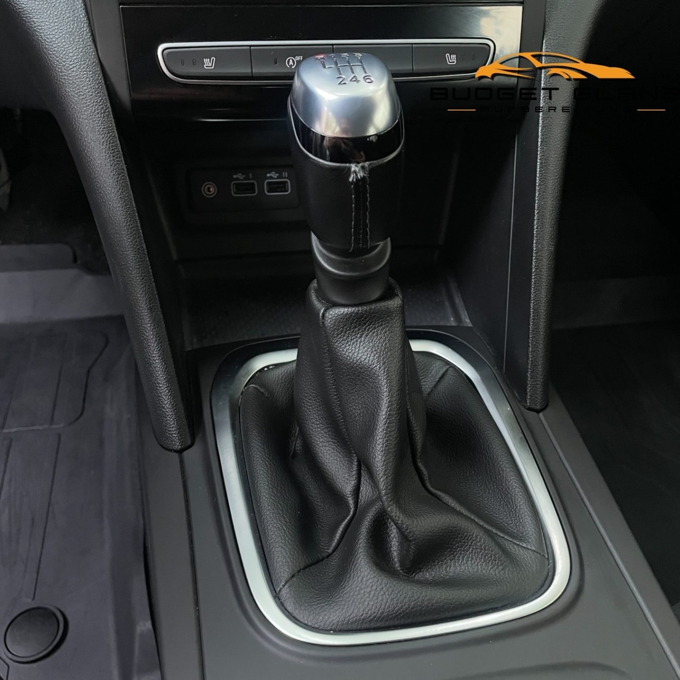 Schalthebel in einem Auto mit Lederumrandung und mittelkonsolarem Design.