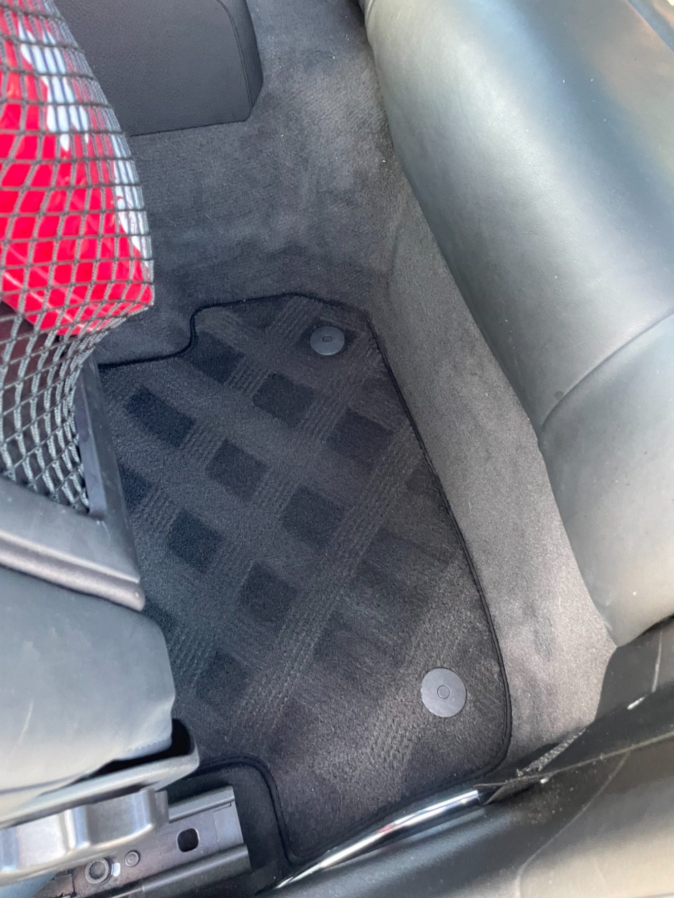 Schwarzer Autoteppich mit rutschfestem Muster im Fußraum.